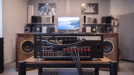 Namų kino stiprintuvo galinė panelė su prijungtais HDMI kabeliais