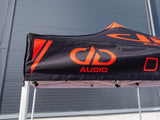 DD Audio Tradeshow-Tent 10″X20″ - juodas tentas su oranžiniu logotipu ir užrašais