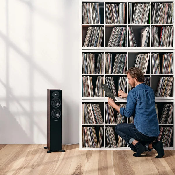 Dynaudio Emit 30, grindinės garso kolonėlės - Kolonėlė su trimis garsiakalbiais ir vyras prie lentynos