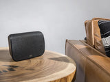Polk Audio MAGNIFI SR1, Belaidės erdvinio garso kolonėlės skirtos MagniFi Max Soundbar'ui - Kolonėlė ant medinio stalo prie odinės sofos